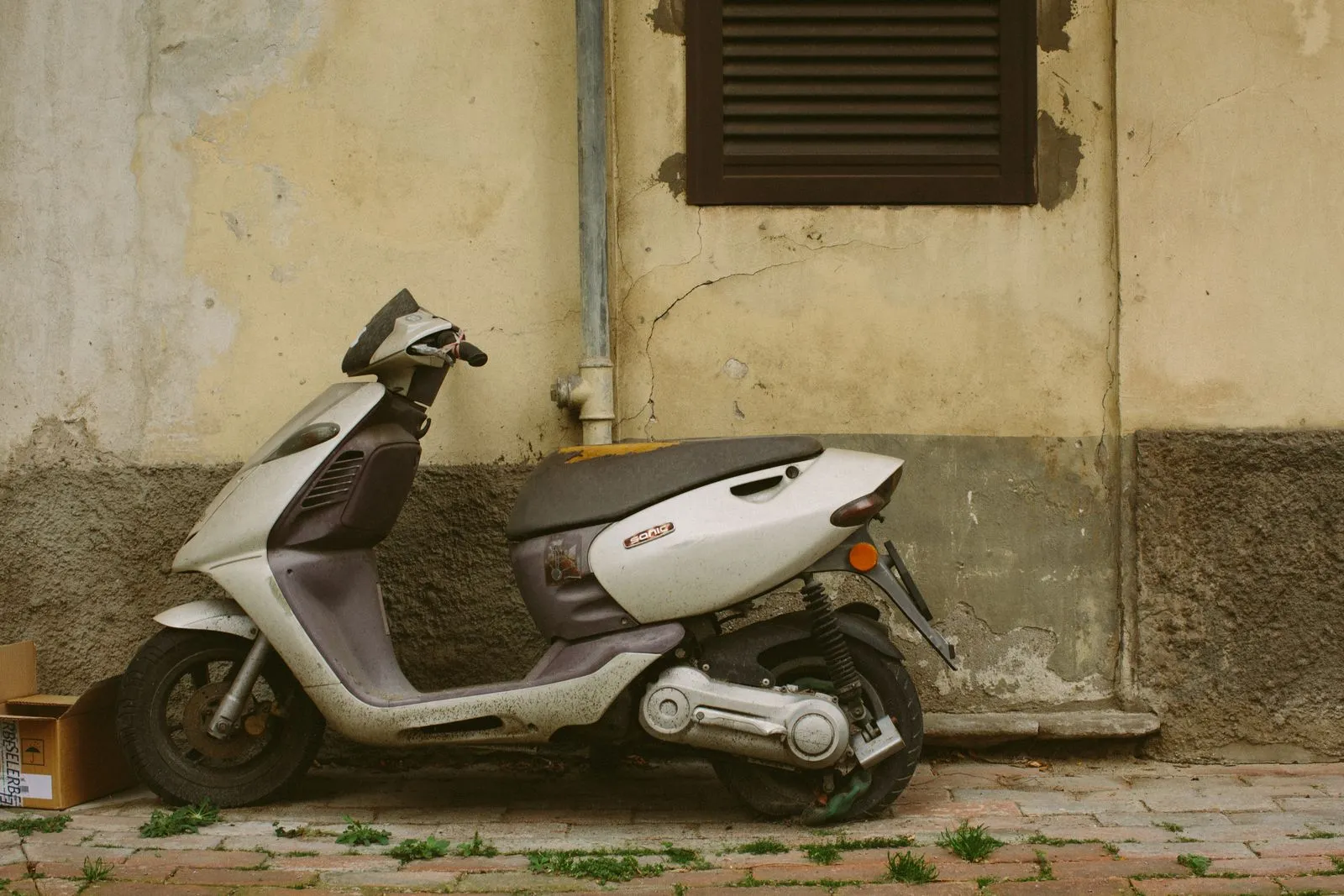 Scooter hors d'usage abandonné contre un mur avant enlèvement d'épave par Épaviste Deux-Roues à Paris et en Île-de-France — moto, scooter, cyclomoteur (75, 77, 78, 91, 92, 93, 94, 95)