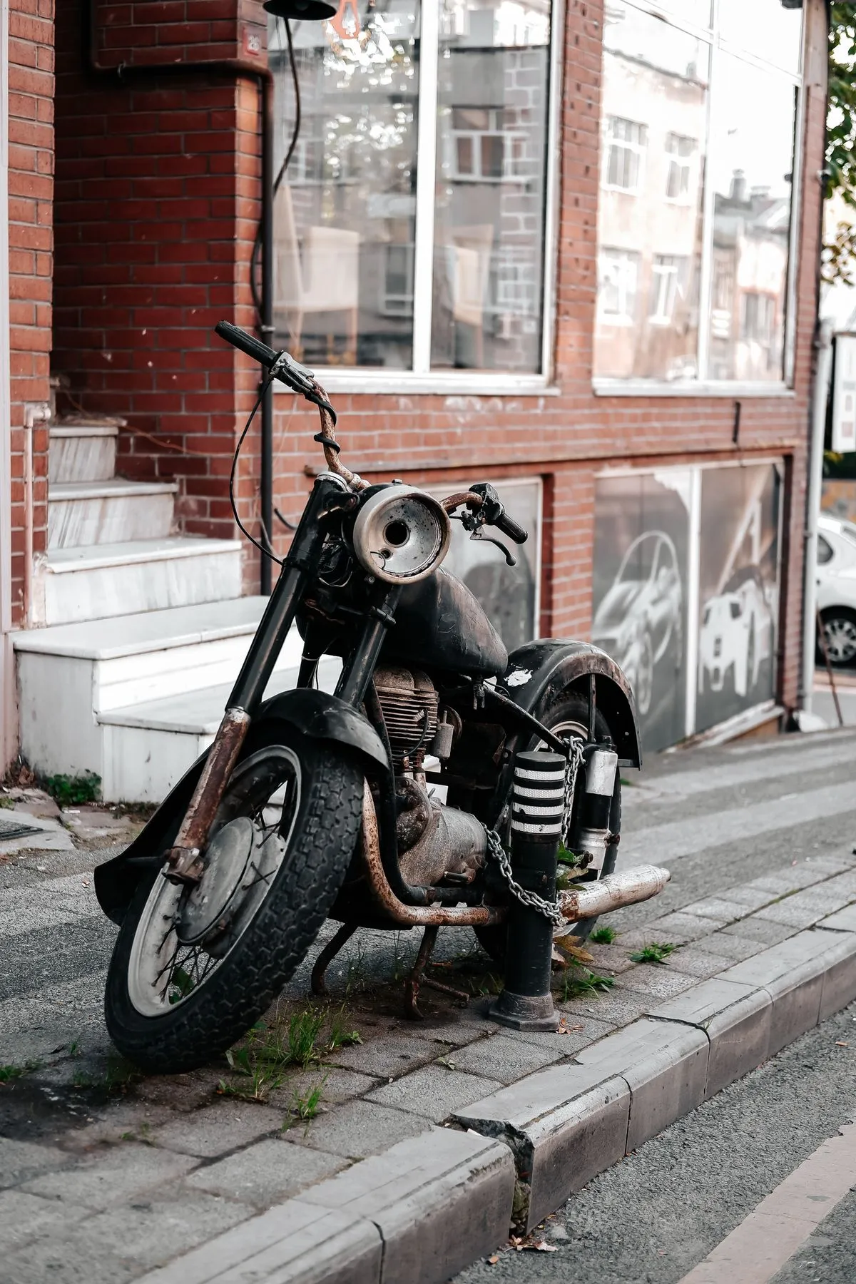Moto épave rouillée abandonnée sur un trottoir — enlèvement de deux-roues accidenté ou brûlé en Île-de-France